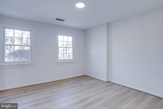 spare room featuring a healthy amount of sunlight and light hardwood / wood-style floors