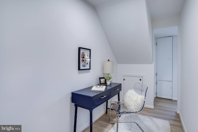 home office with vaulted ceiling and light hardwood / wood-style floors