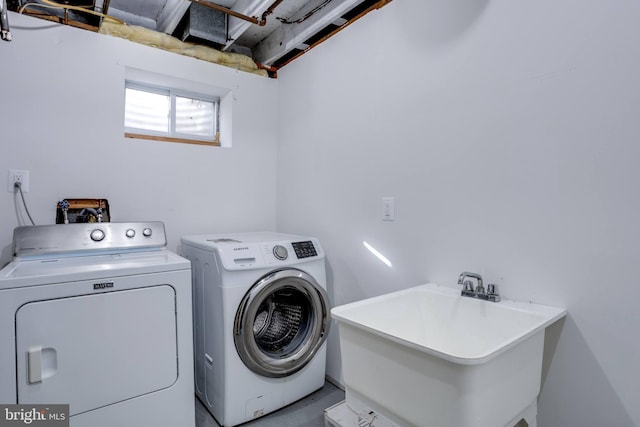 clothes washing area featuring sink and washer and dryer