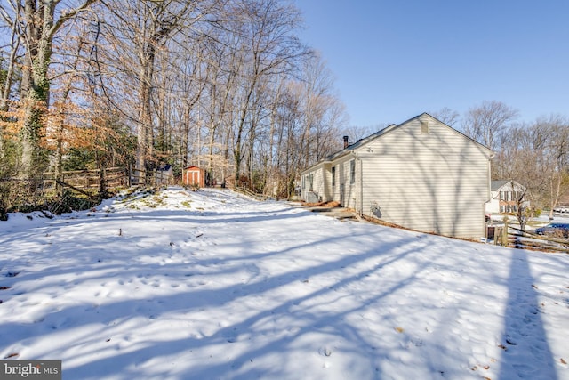 snowy yard with a shed