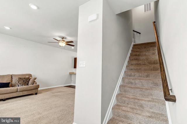 stairs with carpet flooring and ceiling fan