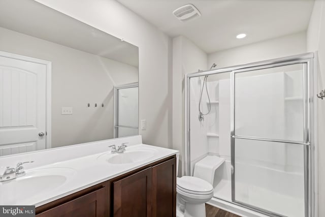 bathroom featuring vanity, hardwood / wood-style floors, toilet, and walk in shower