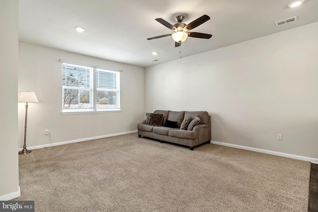 living area featuring ceiling fan and carpet