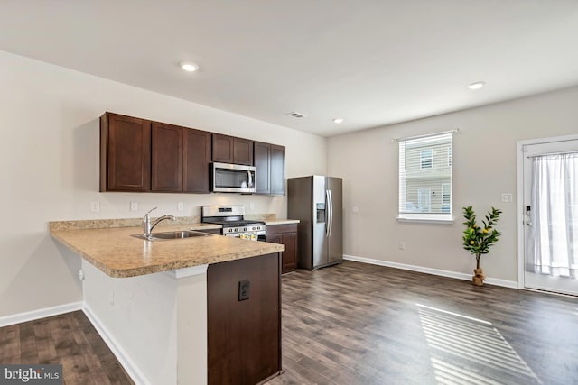 kitchen with stainless steel appliances, sink, dark wood-type flooring, and dark brown cabinetry