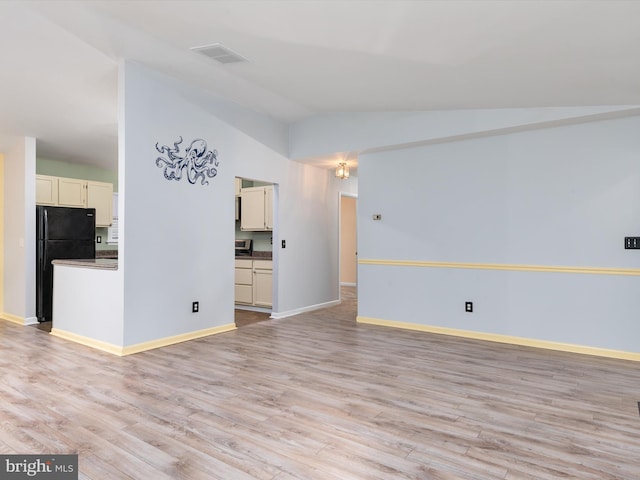 unfurnished living room featuring light hardwood / wood-style flooring and vaulted ceiling