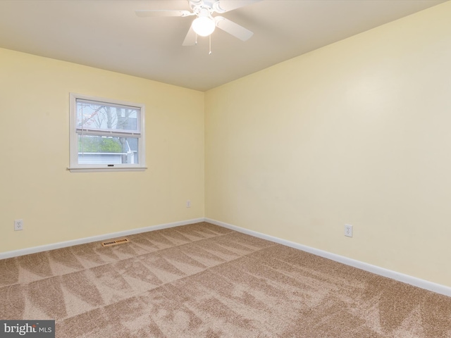 carpeted spare room featuring ceiling fan