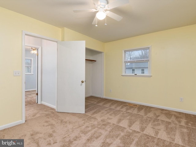 unfurnished bedroom featuring light colored carpet, ceiling fan, and a closet