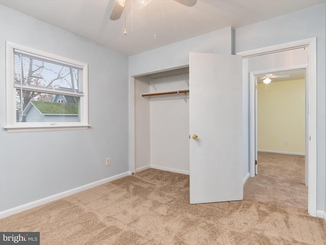 unfurnished bedroom featuring light colored carpet, ceiling fan, and a closet