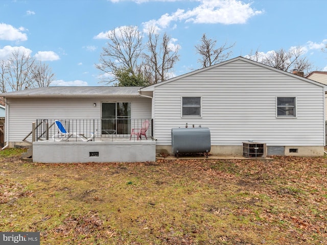 rear view of property featuring central AC, a deck, and a lawn