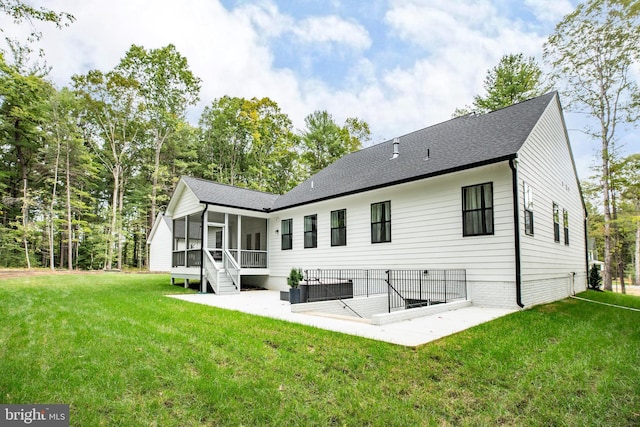 back of house with a patio area, a sunroom, and a lawn