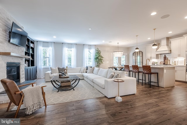 living room with a fireplace and dark wood-type flooring