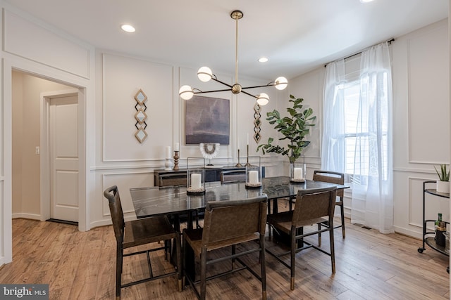 dining space with a chandelier and light wood-type flooring