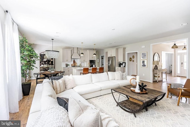 living room with french doors, a healthy amount of sunlight, and light hardwood / wood-style flooring