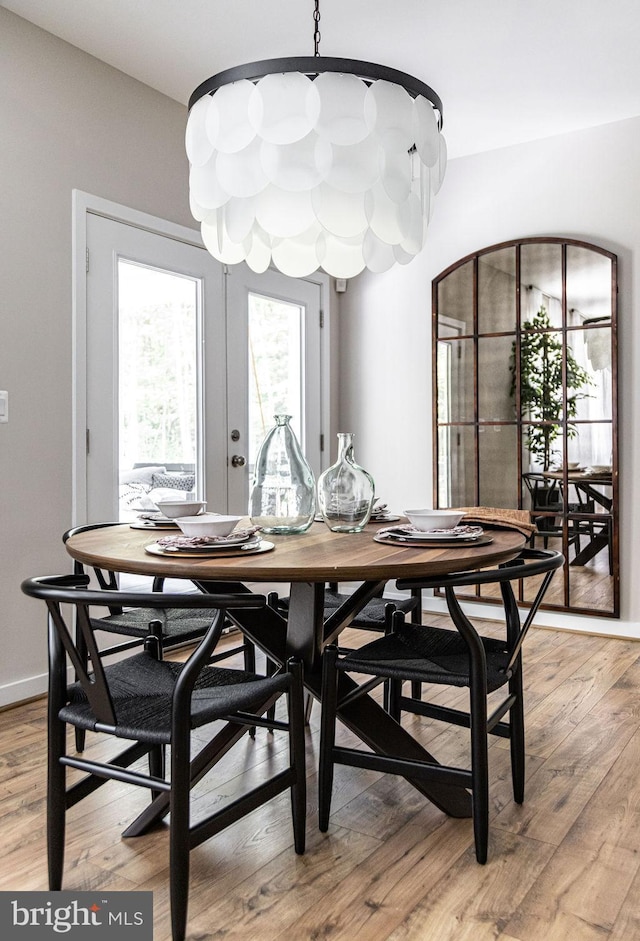 dining space with hardwood / wood-style flooring and french doors