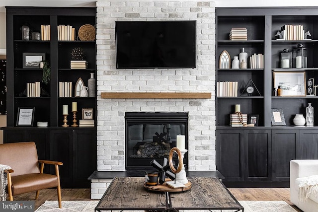 living room featuring a brick fireplace and light hardwood / wood-style floors