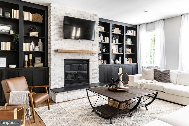 living room featuring a fireplace, hardwood / wood-style floors, and built in features