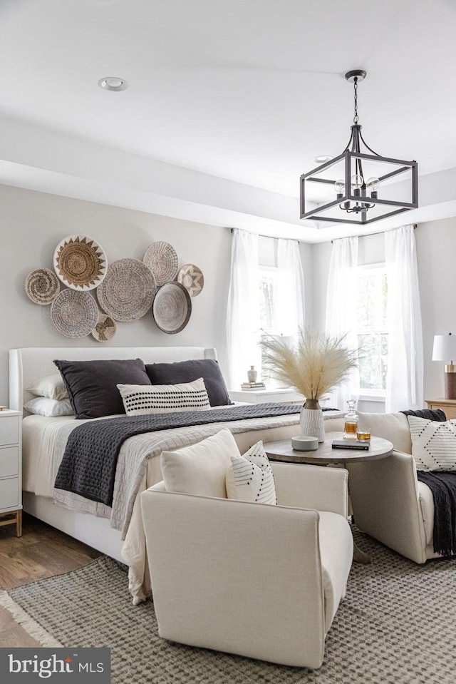 bedroom featuring an inviting chandelier and hardwood / wood-style flooring