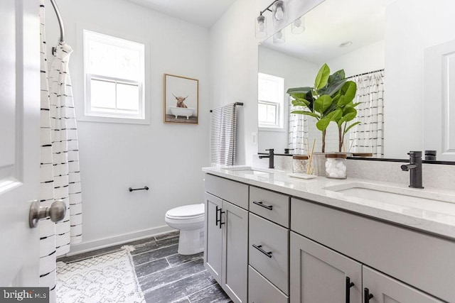 bathroom featuring vanity, plenty of natural light, and toilet