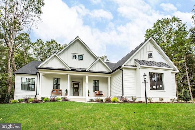 modern inspired farmhouse featuring covered porch and a front lawn