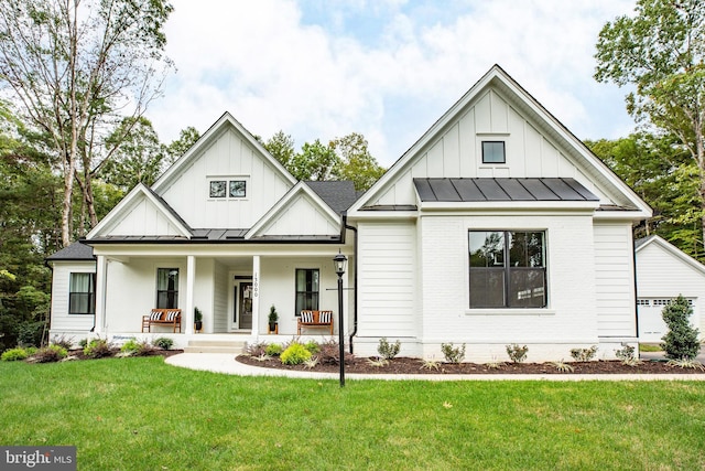 modern farmhouse with covered porch and a front lawn