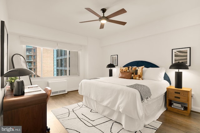1727 Massachusetts Ave NW Unit 307, Washington, DC 20036 - bedroom with wood finished floors, baseboards, a ceiling fan, and heating unit