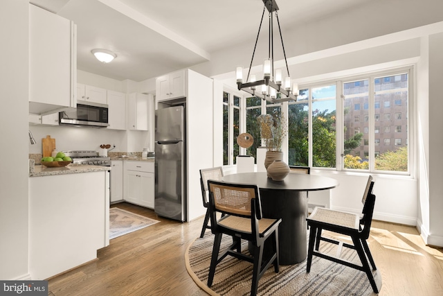 1727 Massachusetts Ave NW Unit 307, Washington, DC 20036 - dining space with a chandelier, light wood-style flooring, and baseboards