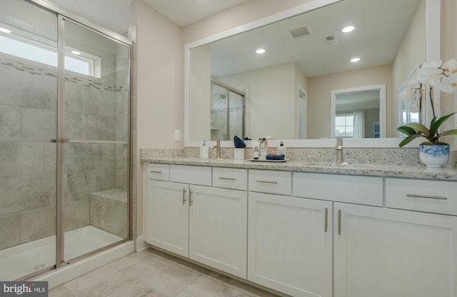 bathroom with vanity, a healthy amount of sunlight, and walk in shower