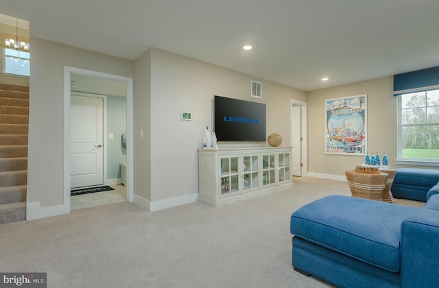 carpeted living room with a chandelier