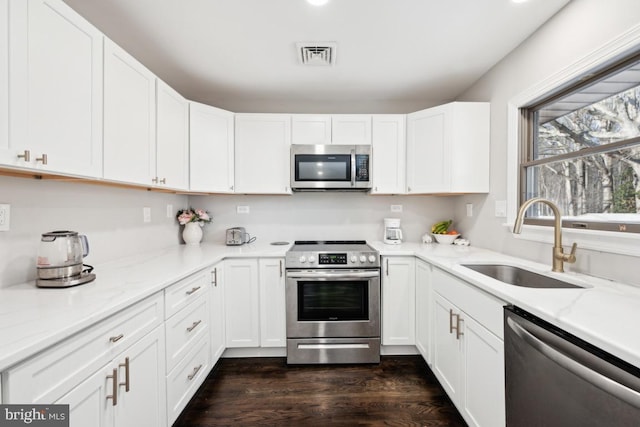 kitchen with white cabinetry, appliances with stainless steel finishes, sink, and dark wood-type flooring