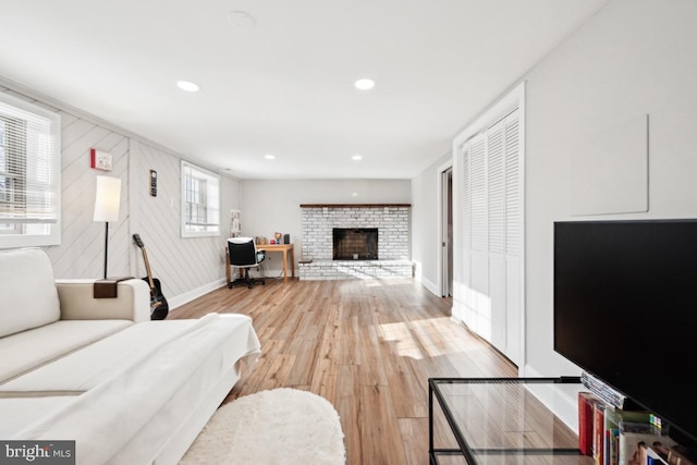 living room featuring hardwood / wood-style flooring and a brick fireplace