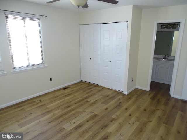 unfurnished bedroom featuring multiple windows, sink, a closet, and ceiling fan