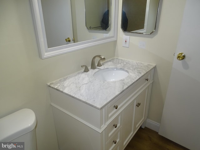 bathroom with vanity, wood-type flooring, and toilet