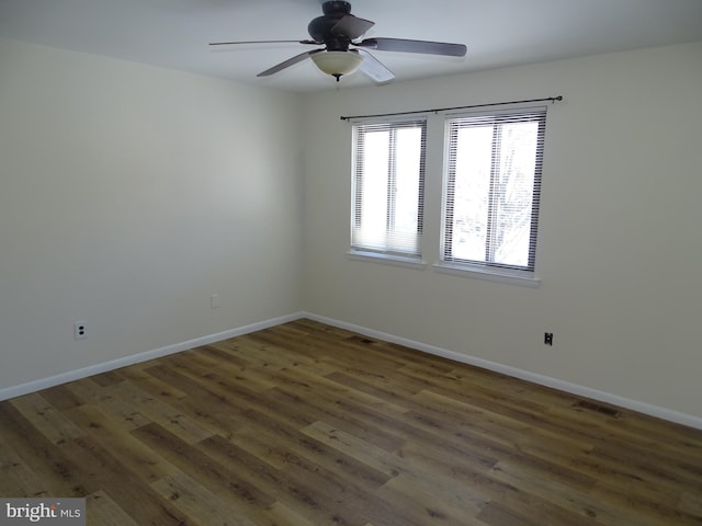 spare room featuring dark wood-type flooring and ceiling fan