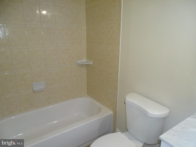 full bathroom with vanity, tiled shower / bath combo, and toilet