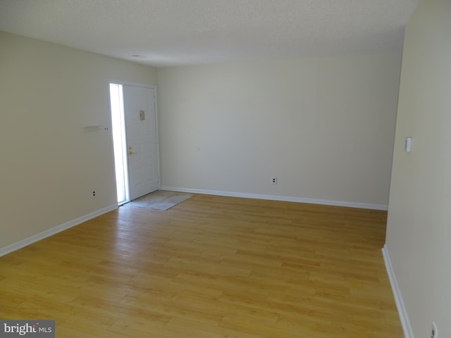 empty room featuring a textured ceiling and light wood-type flooring