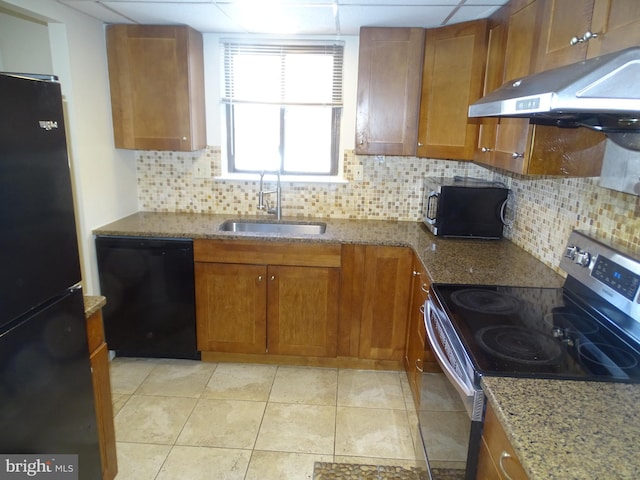 kitchen with light tile patterned flooring, tasteful backsplash, sink, black appliances, and light stone countertops