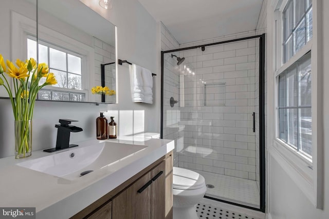 bathroom with walk in shower, vanity, and toilet