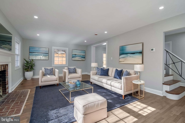 living room with hardwood / wood-style flooring and a brick fireplace