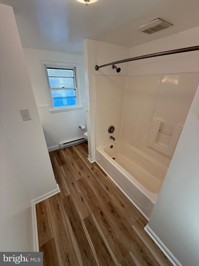 bathroom featuring a baseboard radiator, toilet, tub / shower combination, and hardwood / wood-style floors