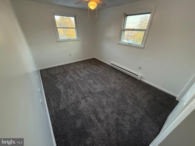 carpeted empty room featuring a wealth of natural light, ceiling fan, and baseboard heating