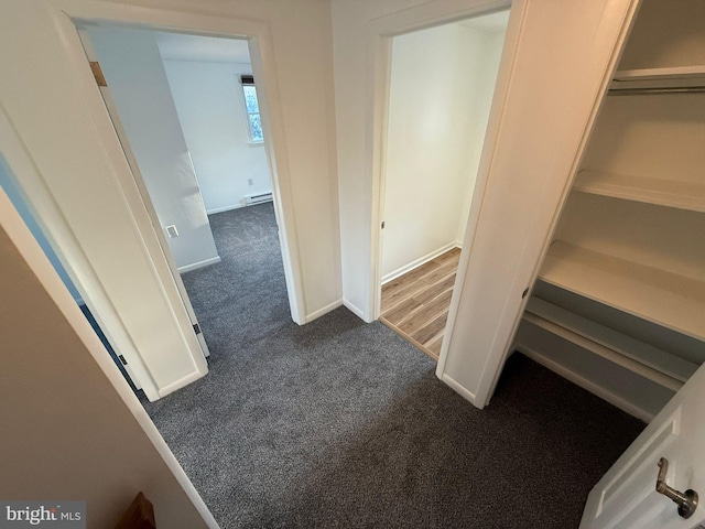 hall featuring light colored carpet and baseboard heating