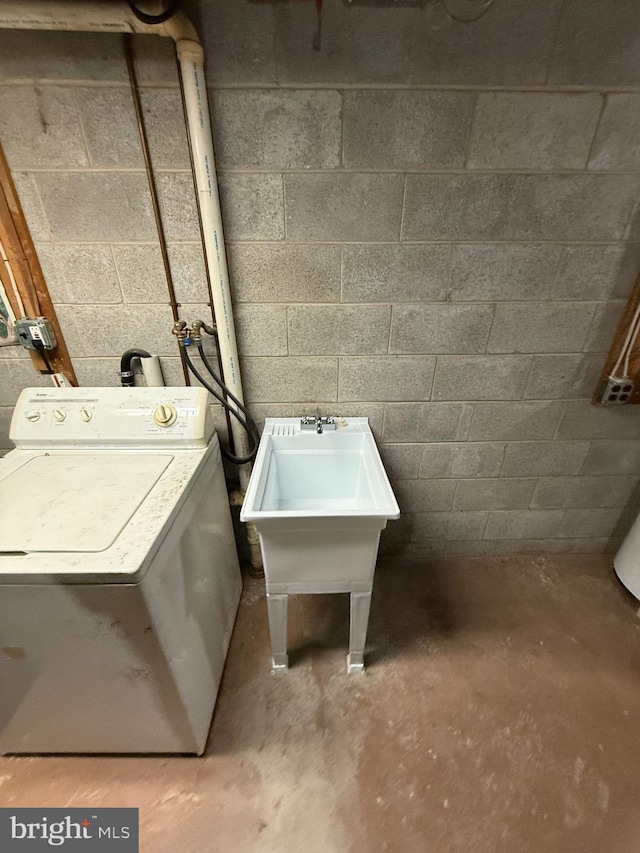 clothes washing area featuring washer / clothes dryer and sink