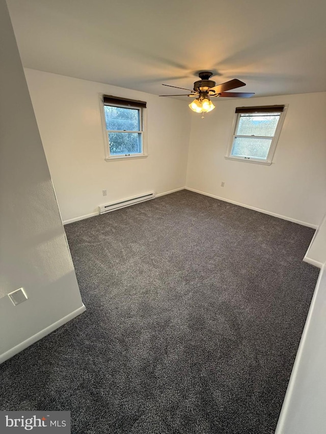 carpeted empty room featuring plenty of natural light, a baseboard heating unit, and ceiling fan