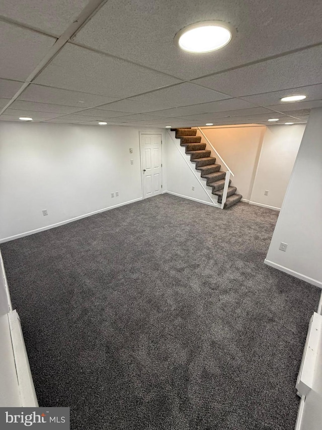 basement with dark carpet and a drop ceiling