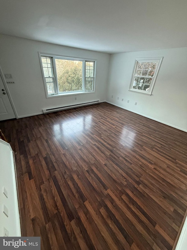 unfurnished room featuring dark hardwood / wood-style floors and baseboard heating