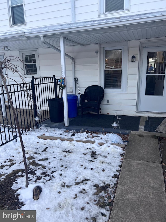 snow covered deck featuring a porch