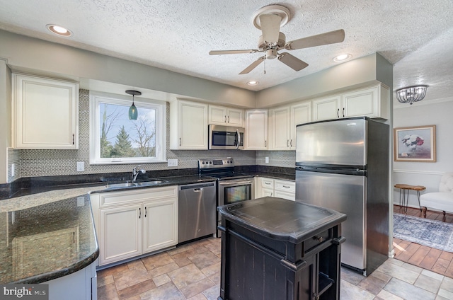 kitchen with sink, white cabinets, hanging light fixtures, a center island, and stainless steel appliances