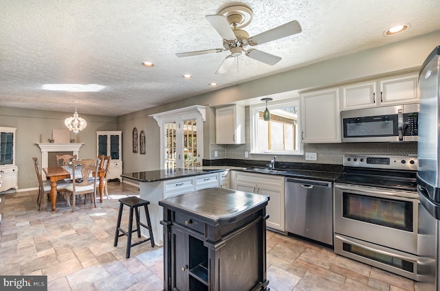 kitchen with white cabinetry, decorative light fixtures, tasteful backsplash, and stainless steel appliances