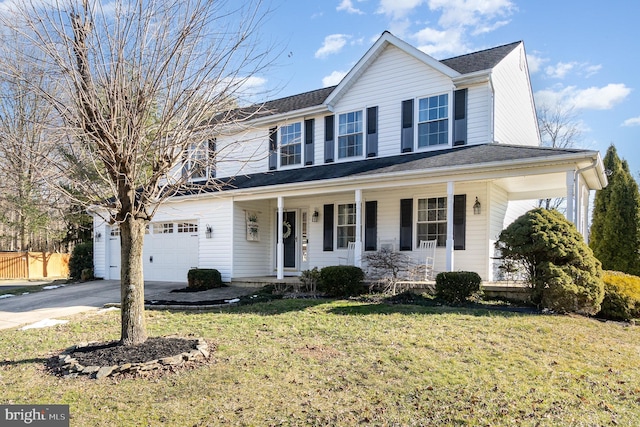 view of front of house with a garage, a front yard, and covered porch