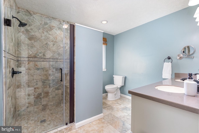 bathroom with vanity, toilet, an enclosed shower, and a textured ceiling